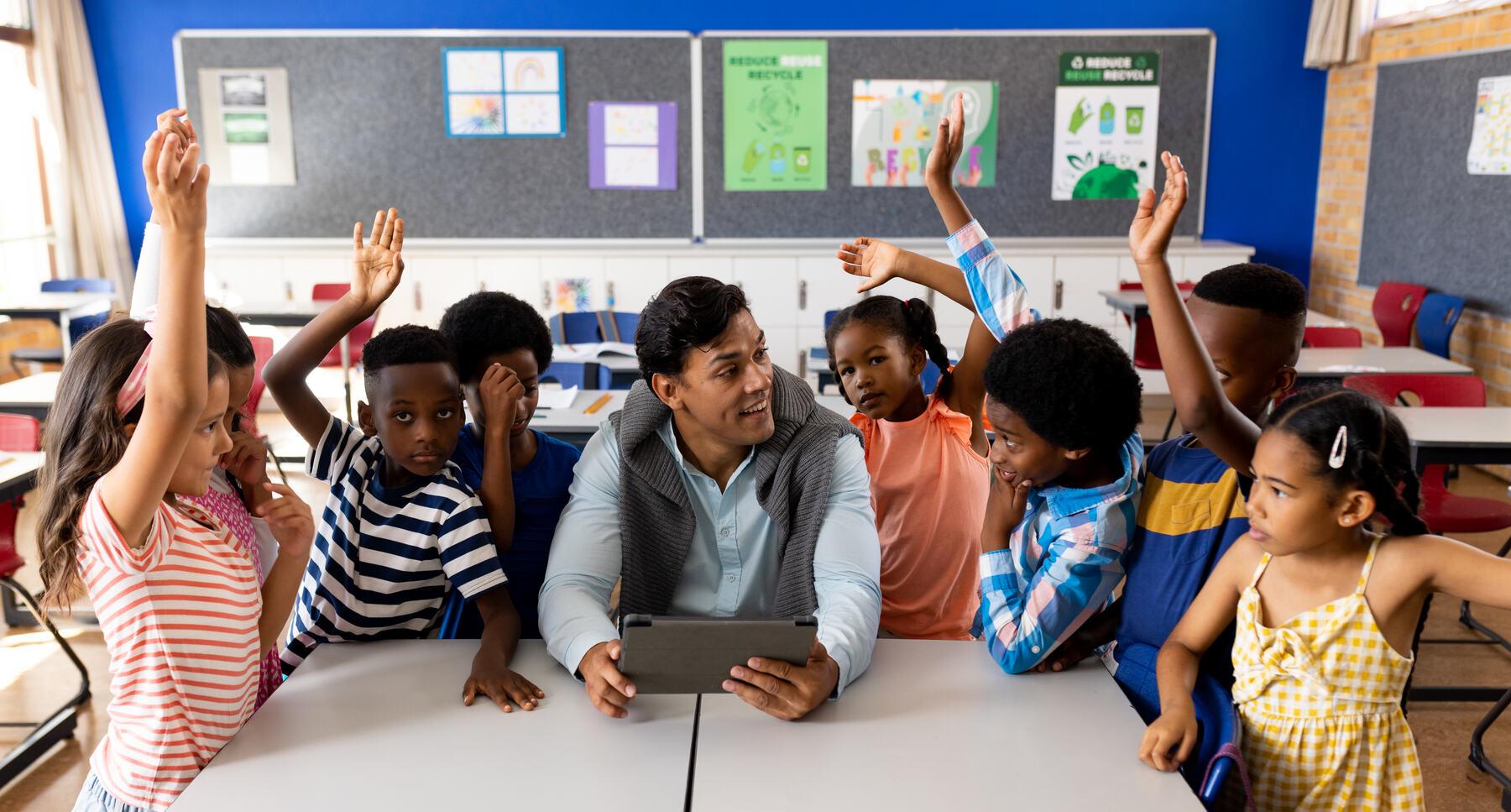 Teacher guiding a small group of students with a tablet